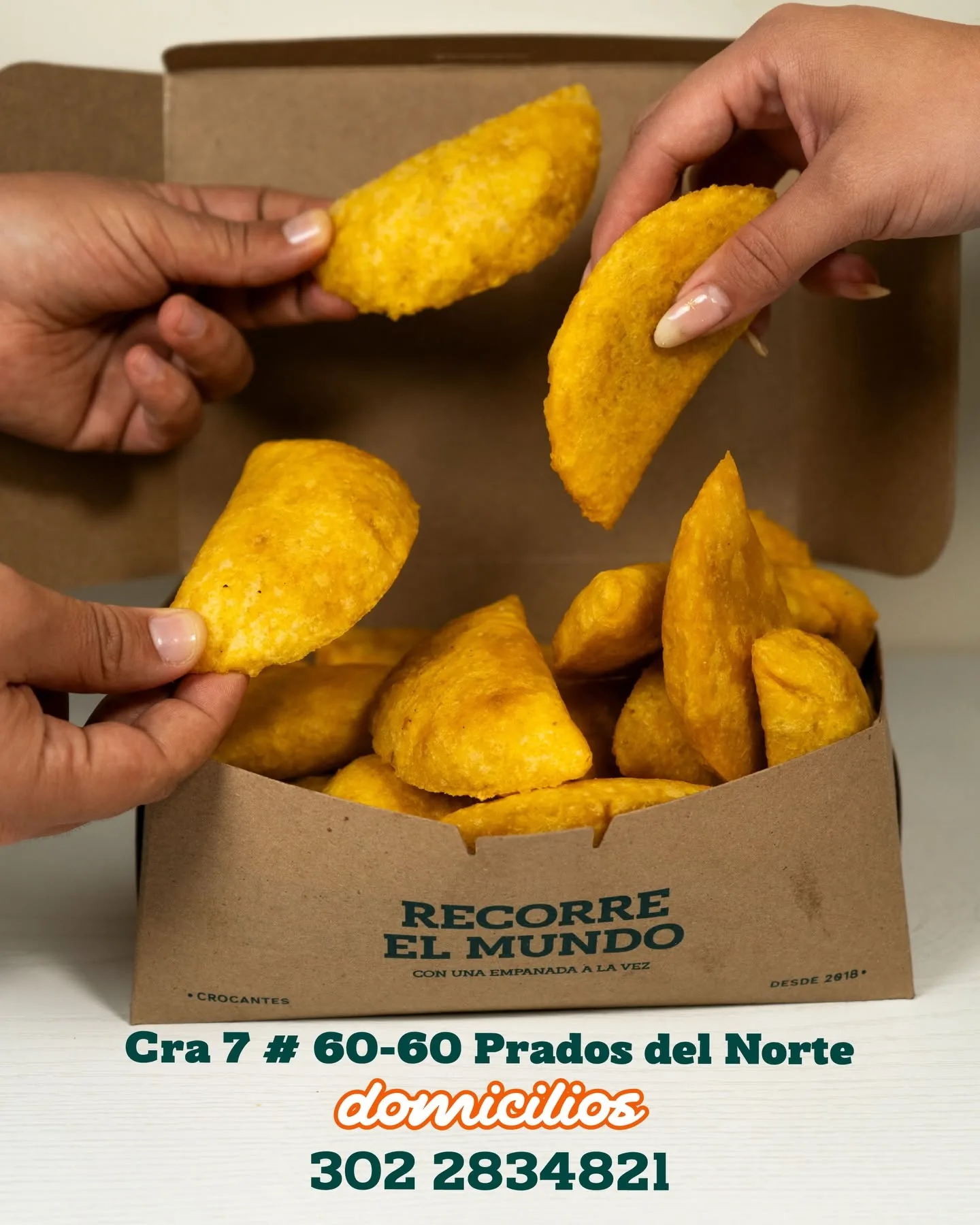 Caja de empanadas Empanadeando compartida entre varias manos